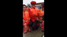 Hundreds of people wearing life jackets attend weddings in flood waters in Vietnam