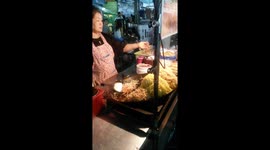 Thaïlandaise qui cuisine Padthaï