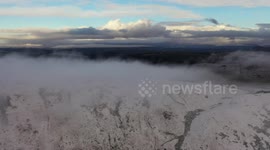 Dramatic Cloud Inversion Over Snowy Summit At Dawn - Drone Clip 12