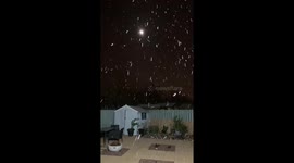 Snow falls over full moon in Belfast, Northern Ireland