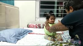 Adorable baby pretends to fall down as mom gestures to push her in mock fight