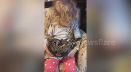 Florida girl holds pet python on her lap as it slithers on couch