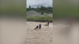 Brave rescuers use zip-line to carry baby over flooded river in Philippines