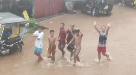Filipino Youngsters Walk Through Floods During Tropical Depression Vicky