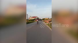 Cyclist Balances Metal Sheet On His Head
