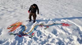 Chinese farmer sprays paint onto snow creating impressive winter artwork