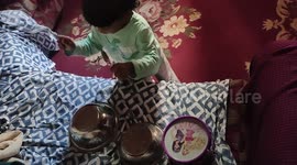 Crazy and adorable two-year-old plays drums using steel bowls and spoons in India