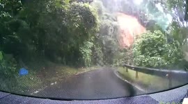 Landslide crashes onto road just yards from an oncoming car during storm in Malaysia