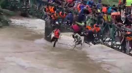 Locals swim through raging river to catch their supper after dam was opened during floods (alternate angle)