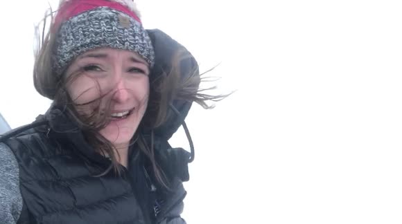 Woman struggles to stand in wind from Canadian blizzard