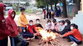 Shivering schoolchildren have classes around campfires as temperatures plunge in northern Thailand