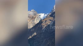 Spectacular avalanche cascades down mountain into glacier lake in Nepal