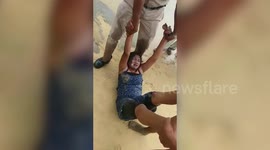 Coastal security personnel rescue drowning woman at beach in southern India