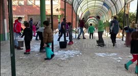 Families clean the snow from access to schools in Madrid 17th January, 2021.