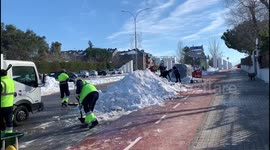 Families clean the snow from access to schools in Madrid 17th January, 2021.
