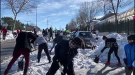 Families clean the snow from access to schools in Madrid 17th January, 2021.