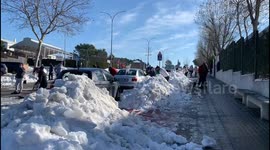 Families clean the snow from access to schools in Madrid 17th January, 2021.