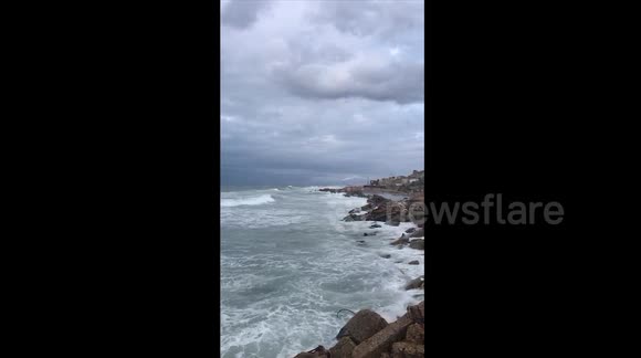 Palestinians brave the rainy weather for a walk on the beach