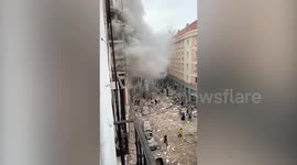 Cloud of smoke rises from building after explosion scatters debris across Madrid road