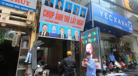 Vietnamese card photography shop attracts customers by displaying pictures of billionaires and US presidents