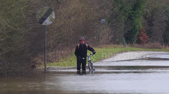 Cyclist battles through floods on a road in West Yorkshire