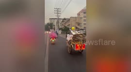 Chinese girl attempts to keep father out of rain by using hand fan