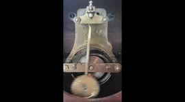 Ticking mechanical desk clock showing bob and mainspring