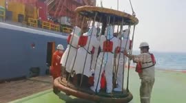 Customs officials transported in cage to do COVID-19 check on large-scale ship as it is too big to stop near port