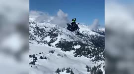This unbelievable footage shows the moment an athlete rode his snowbike off the edge of a cliff