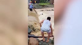 Heartwarming moment senior citizen braves flooded river to save his pet dog in the Philippines