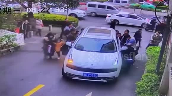 Watch the moment heroic passersby in China lift up a car to free boy ...