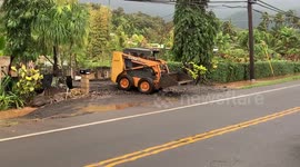 Man clearing his driveway with caterpillar after heavy rain flooded his property on oahu in hawaii