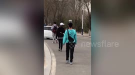 University students in China walk around campus with bowls balanced on heads
