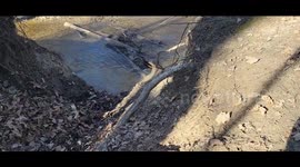 Small Creek With Planes Flying Overhead partially, Water Is Going Over Sticks