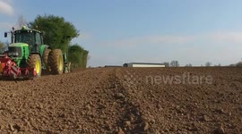 A tractor and sowing drill planting Flax, or Linseed in the fields of northern France