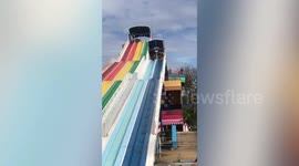 Woman pushes herself down waterpark slide which is not slippery enough