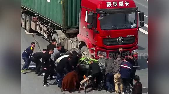 Passersby in China lift up three-wheeler to free rider trapped ...