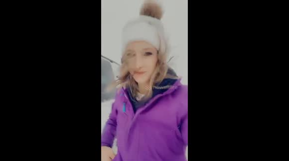 Canadian woman walking in blizzard carrying 120 on hour winds