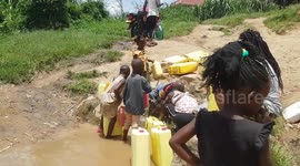 Children try to earn money by collecting water in cans for other people in Kawempe, Uganda