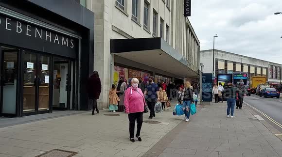 Shoppers queue outside Debenhams on 12 April first day of shops reopening