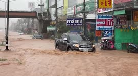 Cars drive through flooded roads after heavy rain in Thailand
