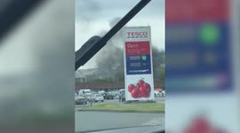 A man’s car was seen engulfed in flames after it caught fire in a Tesco car park