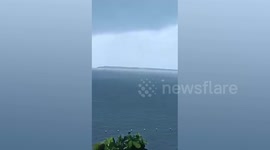 Waterspout forms next to boat off the coast of the Philippines