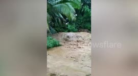 Muddy river overflows after heavy rain in the Philippines