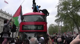 Packs of Palestinian protesters climb atop bus in Whitehall, London
