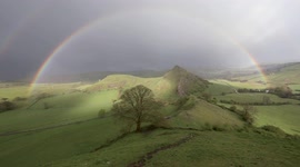 Breath-taking double rainbow forms above famous hillside ridge in the Peak District, UK