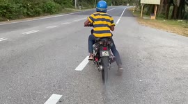 Motorcycle rider waits for road to clear only to lose control and crash straight into bush