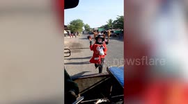 Street vendors chase vehicles to offer grilled chicken to tourists in Laos