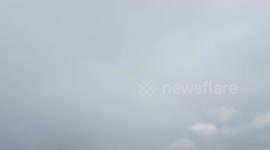Rainbow appears on hill after heavy rain came down on Sunday