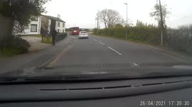 Cyclist riding dangerously close to the back of a bus, initionaly thought he was actually holding on to it.